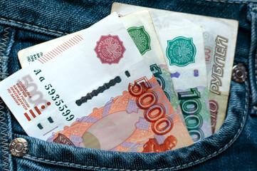 Obraz premium Several ruble banknotes. Rubles in a jeans pocket. Jeans. Close-up. Selective focus.