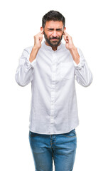 Adult hispanic man over isolated background covering ears with fingers with annoyed expression for...