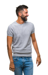 Fototapeta premium Adult hispanic man over isolated background looking away to side with smile on face, natural expression. Laughing confident.