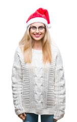 Young beautiful blonde woman wearing christmas hat over isolated background with a happy and cool smile on face. Lucky person.