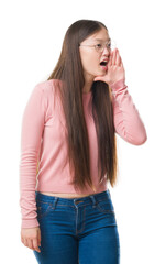 Fototapeta premium Young Chinese woman over isolated background wearing glasses shouting and screaming loud to side with hand on mouth. Communication concept.