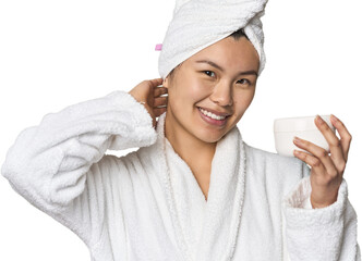 Chinese woman with moisturizer in robe touching back of head, thinking and making a choice.