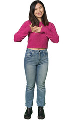 Full-body young Chinese woman has friendly expression, pressing palm to chest. Love concept.