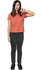 Full-body young Chinese woman showing a dislike gesture, thumbs down. Disagreement concept.