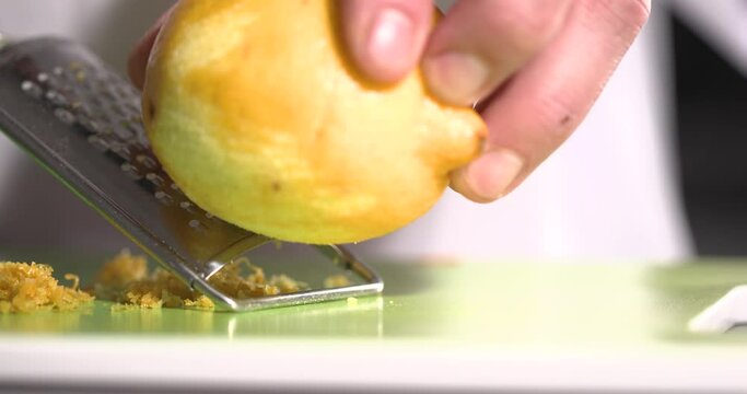 Grating lemon zest on a fine grater.