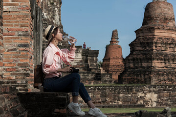 Fototapeta premium Thailand tourism, Ayutthaya, female travel in Asia, sightseeing tourist attraction with large pagoda and beautiful Buddhist attractions in historical park, tourism concept.