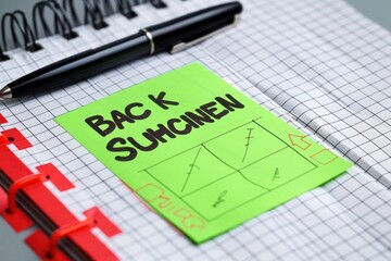 Back to School reminder on green post-it, white graph with red tabs and pen,