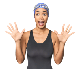 Pro Latina swimmer in studio gear receiving a pleasant surprise, excited and raising hands.
