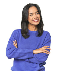 Simple portrait of a young Latina smiling confident with crossed arms.