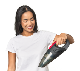 Young Latina using a vacuum cleaner in studio