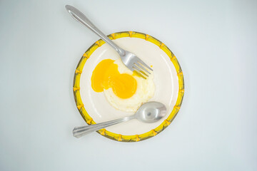 A fried poached egg with yellow poached egg on a plate ready to eat delicious