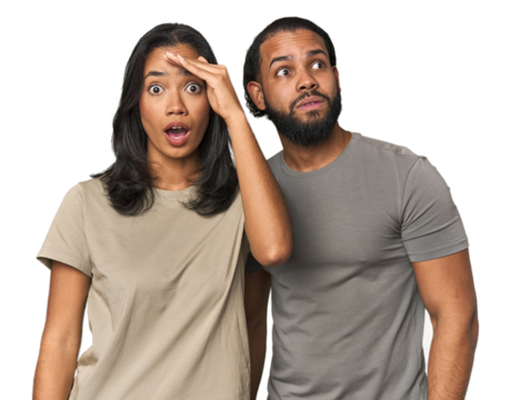 Young Latino couple in studio shouts loud, keeps eyes opened and hands tense.