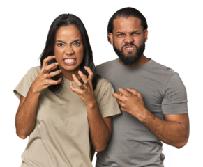 Young Latino couple in studio upset screaming with tense hands.