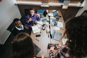 A multiracial team of professionals engaging in a creative brainstorming session at a cluttered...