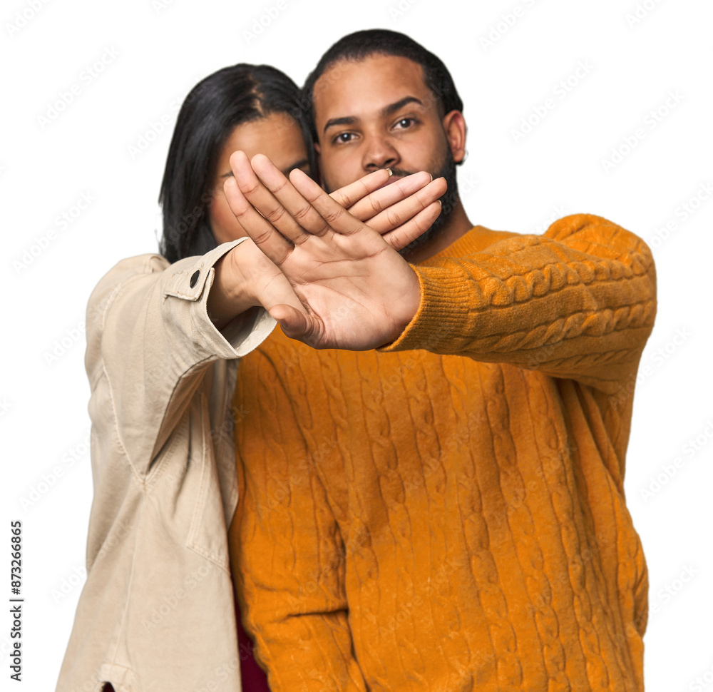 Wall mural young latino couple in studio doing a denial gesture