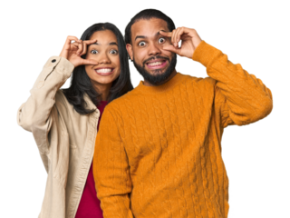 Young Latino couple in studio keeping eyes opened to find a success opportunity.