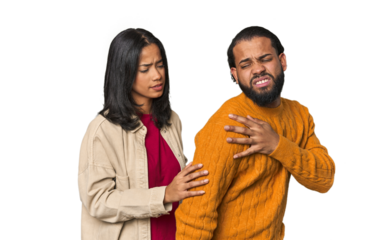 Young Latino couple in studio having a shoulder pain.