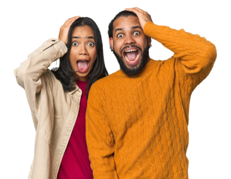 Young Latino couple in studio screaming, very excited, passionate, satisfied with something.