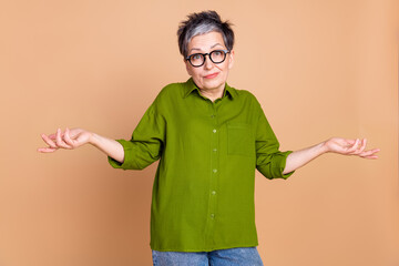 Photo portrait of attractive retired woman shrug shoulders dressed stylish green clothes isolated...