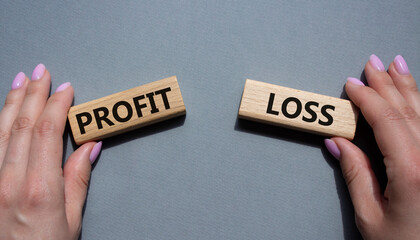 Profit or Loss symbol. Concept word Profit or Loss on wooden blocks. Businessman hand. Beautiful grey background. Business and Profit or Loss concept. Copy space