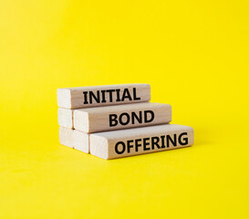 Initial Bond Offering symbol. Concept words Initial Bond Offering on wooden blocks. Beautiful yellow background. Business and Initial Bond Offering concept. Copy space