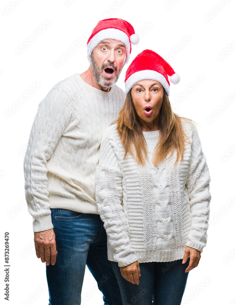 Canvas Prints Middle age hispanic couple wearing christmas hat over isolated background afraid and shocked with surprise expression, fear and excited face.