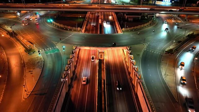 Financial technology, energy power, beautiful top view time-lapse of car traffic at roundabout lane and buildings. 4K drone aerial zoom out. Urban cityscape concept or abstract of advanced innovation.