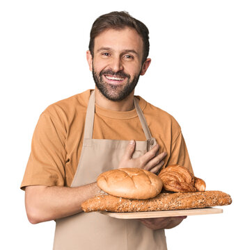 Hispanic male baker with bread tray laughing and having fun.