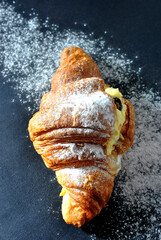 rock on the beach,yellow cake on a black background