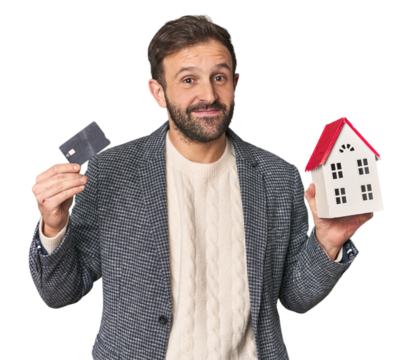 Hispanic male businessman with credit card and house model