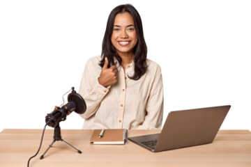 Woman records podcast with laptop smiling and raising thumb up