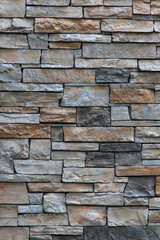 Brown and grey brick stone wall full frame background.