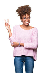 Beautiful young african american woman wearing glasses over isolated background smiling with happy face winking at the camera doing victory sign. Number two.