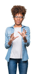 Beautiful young african american woman wearing glasses over isolated background disgusted expression, displeased and fearful doing disgust face because aversion reaction. With hands raised.