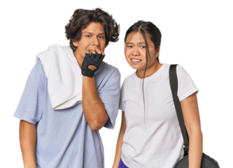 Young interracial athletic couple in studio biting fingernails, nervous and very anxious.