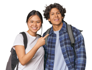 Young interracial student couple studying smiling and pointing aside, showing something at blank space.