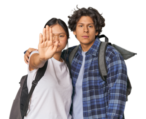 Young interracial student couple studying standing with outstretched hand showing stop sign, preventing you.