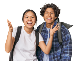Young interracial student couple studying receiving a pleasant surprise, excited and raising hands.