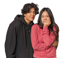 Young interracial couple in studio biting fingernails, nervous and very anxious.