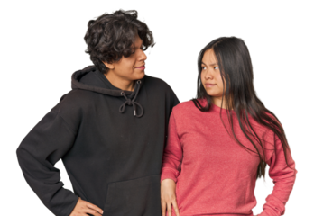 Young interracial couple in studio confused, feels doubtful and unsure.