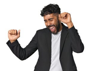 Hispanic businessman in suit in studio dancing and having fun.