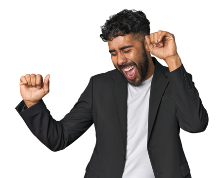 Hispanic businessman in suit in studio dancing and having fun.