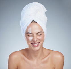 Woman, skincare and laughing in studio with cream for hydration, wellness or cosmetics. Towel,...