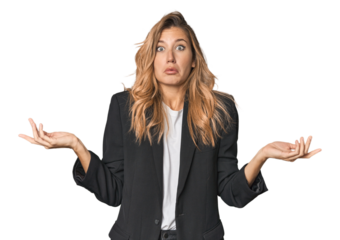 Young businesswoman in a suit doubting and shrugging shoulders in questioning gesture.