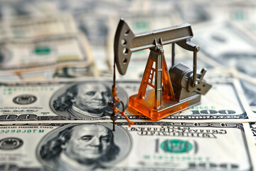 Small Orange Oil Rig Pumpjack on US Dollar Bills