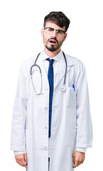 Fototapeta premium Young doctor man wearing hospital coat over isolated background In shock face, looking skeptical and sarcastic, surprised with open mouth
