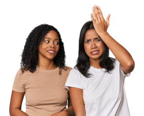 Young Latin friends in studio forgetting something, slapping forehead with palm and closing eyes.