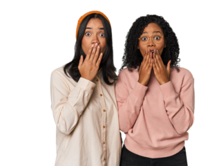 Young Latin friends together in studio shocked, covering mouth with hands, anxious to discover something new.