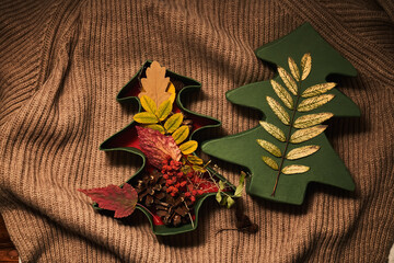 Cozy composition of autumn leaves in the box on sweater.