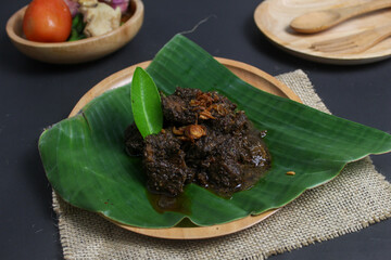 Delicious ready-to-eat beef rendang served on a banana leaf basis.  Indonesian food